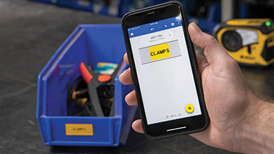 Una persona sosteniendo un teléfono. La pantalla del teléfono muestra una etiqueta amarilla creada usando la app Etiquetas rápidas. En el fondo, hay un tubo de plástico con la etiqueta impresa colocada en él.