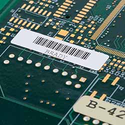 Una etiqueta chica de código de barras en una placa de circuitos.