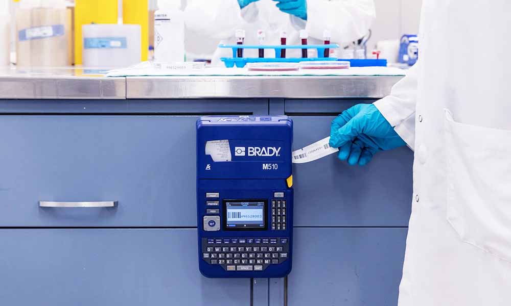 Un químico saca una etiqueta de una impresora de etiquetas M510.