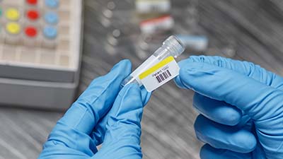 Un químico coloca una etiqueta de código de barras en un vial.