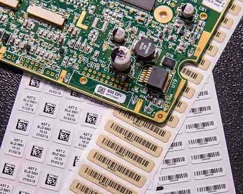 Una etiqueta con texto y un código de barras en una placa de circuitos.