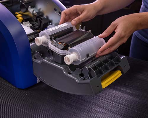 Un cartucho de cinta de impresión siendo instalado en la impresora i5300.