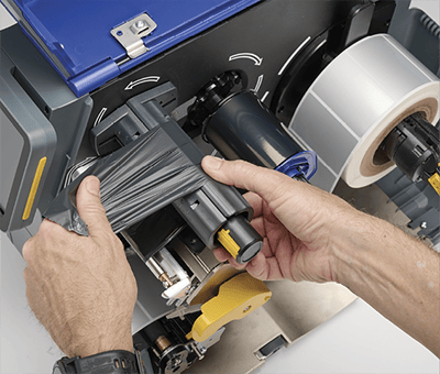 Un empleado carga rápidamente una cinta de impresión nueva en una impresora i7500.