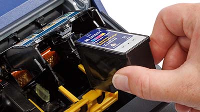 Una persona instalando un cartucho de tinta.