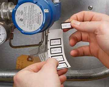 una persona aplicando etiquetas impresas con la M610.