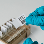 A person identifying a microscopic slide with a barcode label.