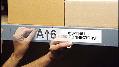 Se está despegando limpiamente una etiqueta de un estante del almacén.