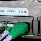 Una etiqueta Brady aplicada sobre un puerto de datos en un equipo para identificar el propósito del puerto.