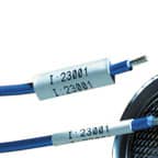 Dos etiquetas termocontráctiles Brady aplicadas a los cables para identificar su propósito.