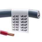 Un primer plano de una etiqueta envolvente de Brady en un cable gris. La etiqueta es blanca con texto negro que se repite para facilitar su reconocimiento.