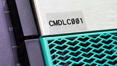 Una pieza de maquinaria con una etiqueta de poliéster transparente con texto negro.