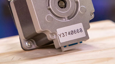 Una pequeña pieza de maquinaria con una etiqueta de poliéster.