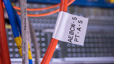 Un cable tiene una etiqueta tipo bandera, que muestra dos líneas de texto.