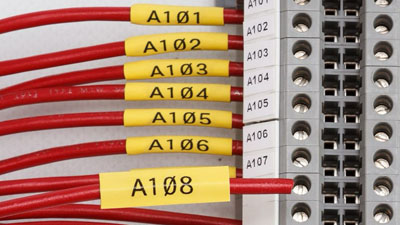 Mangas termocontráctiles que identifican varios cables conectados a un bloque de terminales.